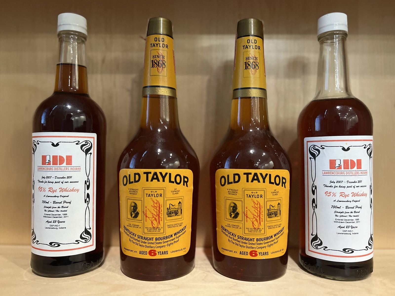 Old Taylor and LDI 95 percent rye bottles on a shelf
